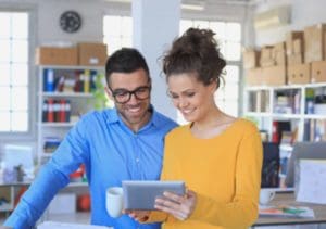 young adults reviewing tablet computer in office
