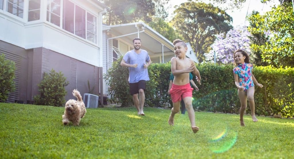 young family running through front yard