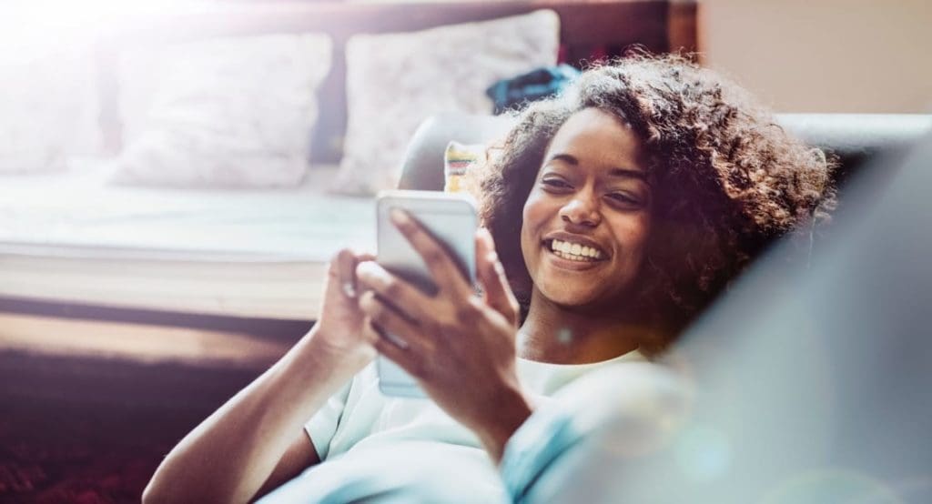 woman using her phone on the sofa