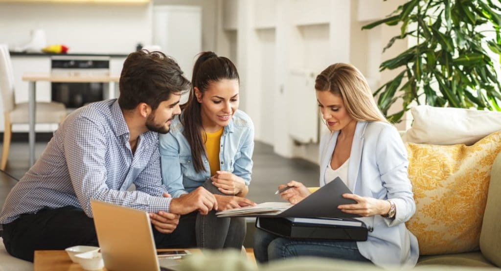 agent reviewing documents with young couple