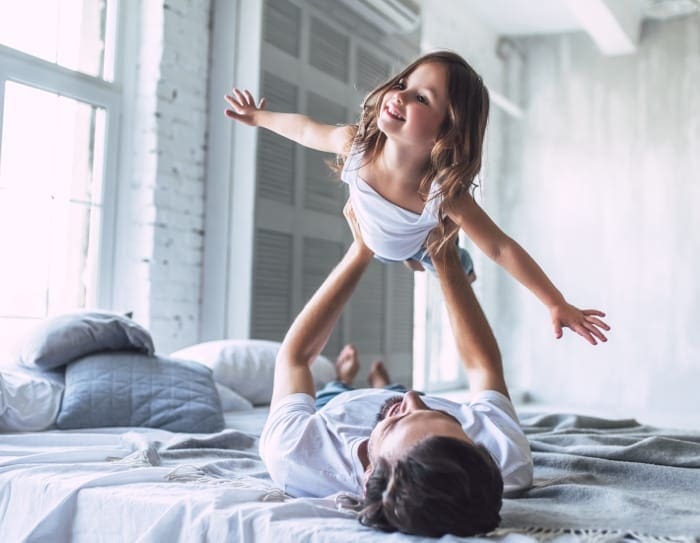 father and daughter playing in home
