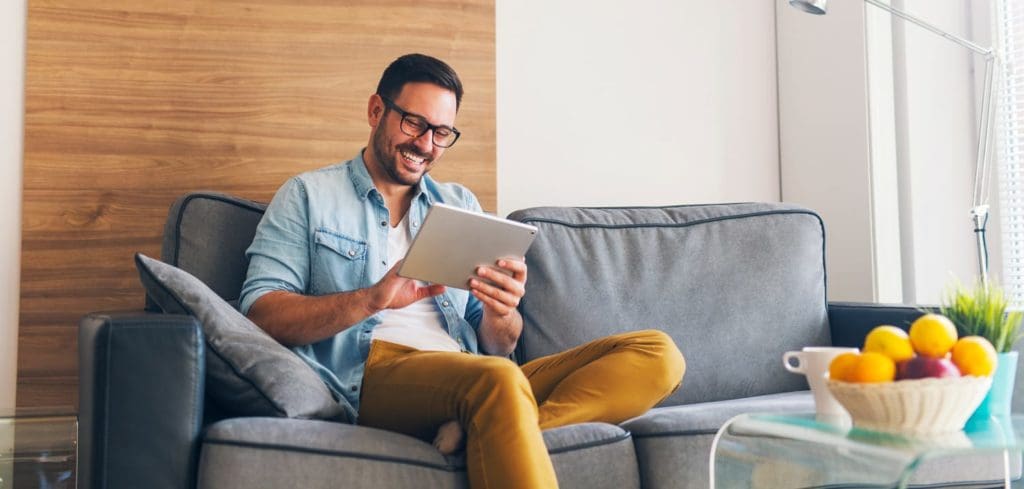 man using tablet computer in home