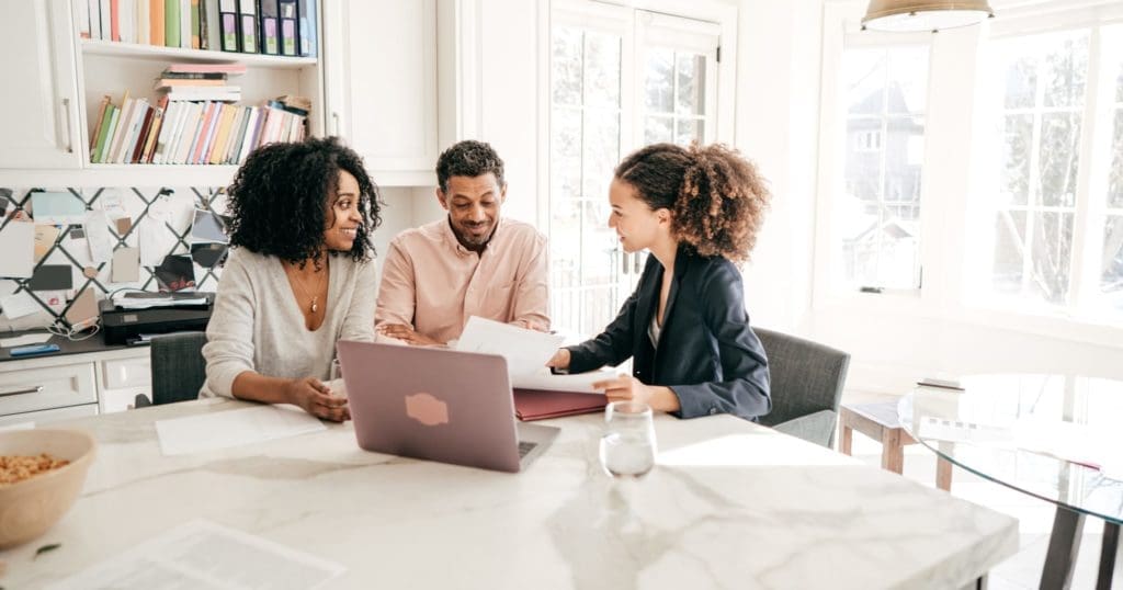 agent reviewing documents with young couple