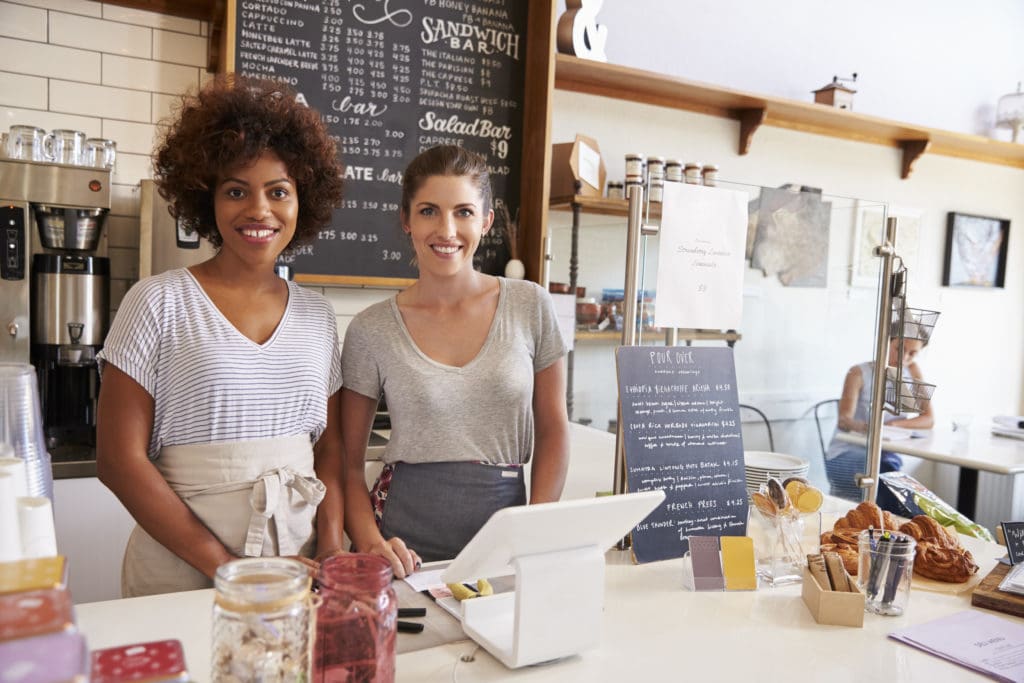 Two women behind the counter at a restaurant.