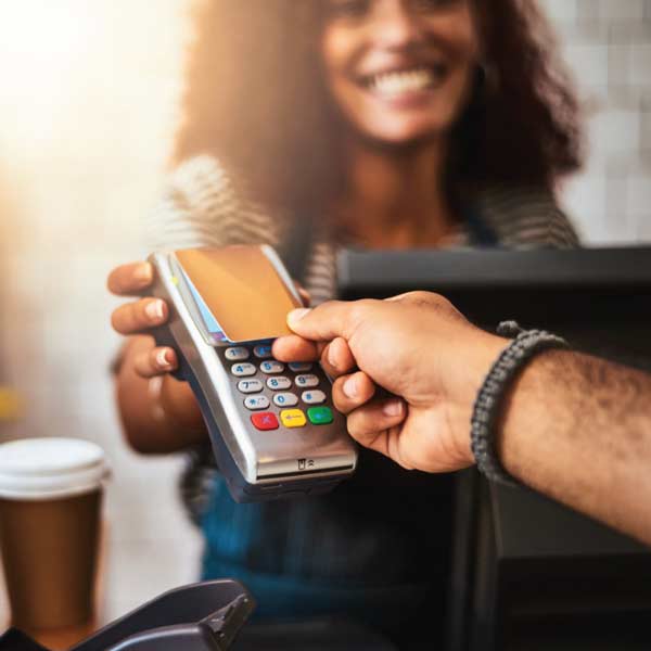 An image of a man tapping his card to pay for a transaction.