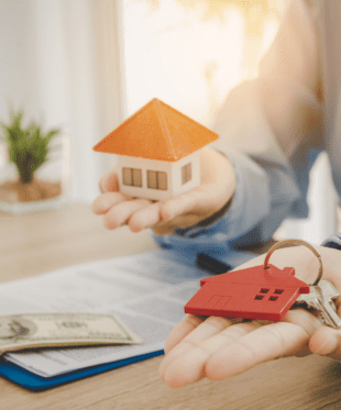 An image of a small toy house and small house silhouette keychain.