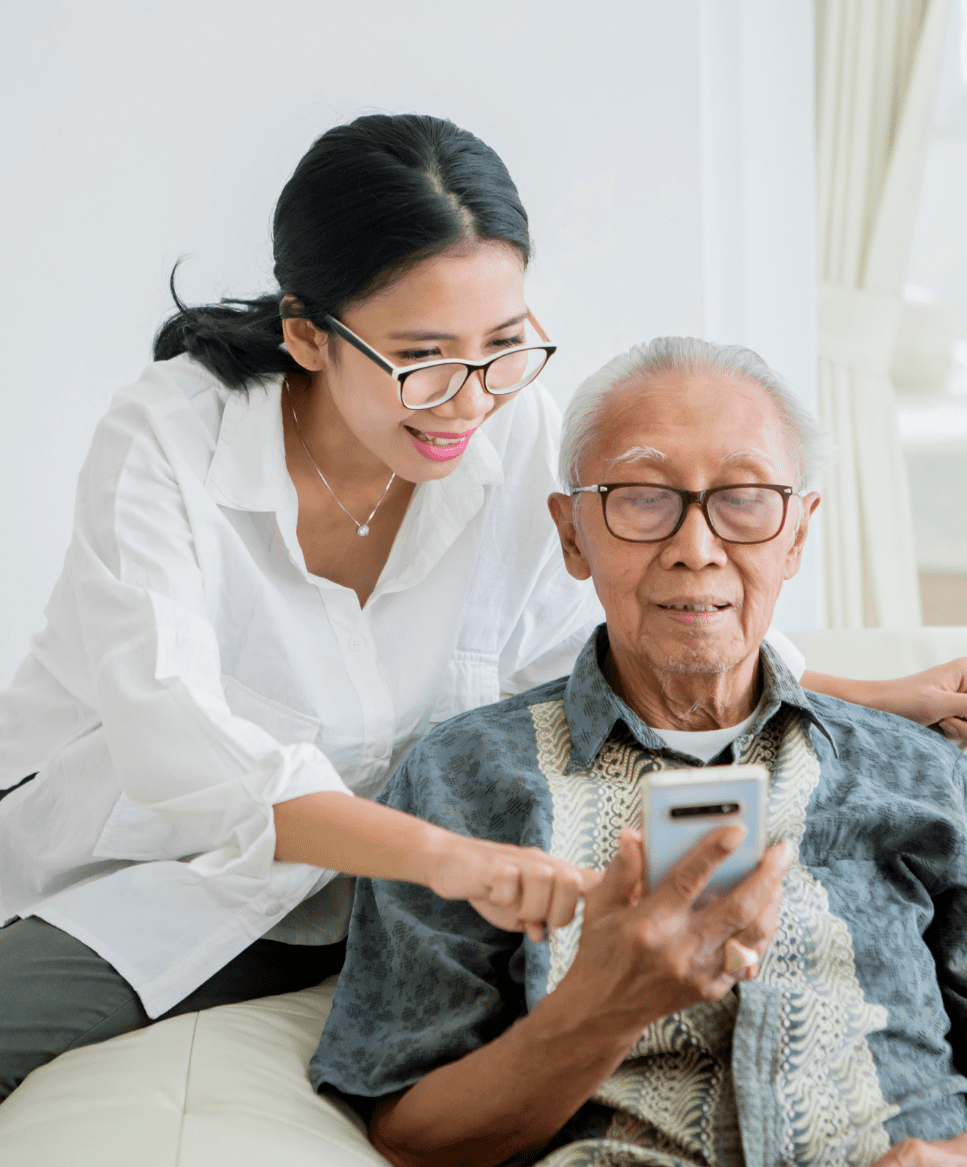 Lady pointing to something on old man's phone